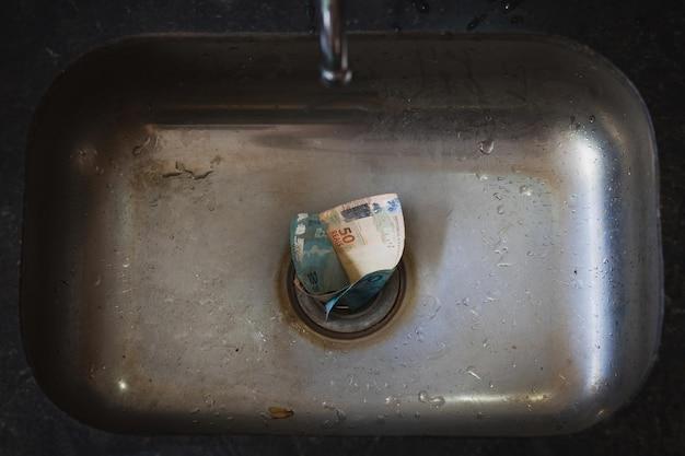 garbage disposal water goes down and comes back up